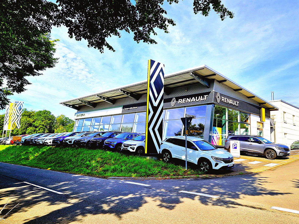 Automobile Clever E-Tech Ein weißer Renault Zoe Drive Clean Be Clever, vollständig elektrisch betrieben. Die Kontaktdaten von Automobile sind auf der Fahrzeugseite angebracht.
