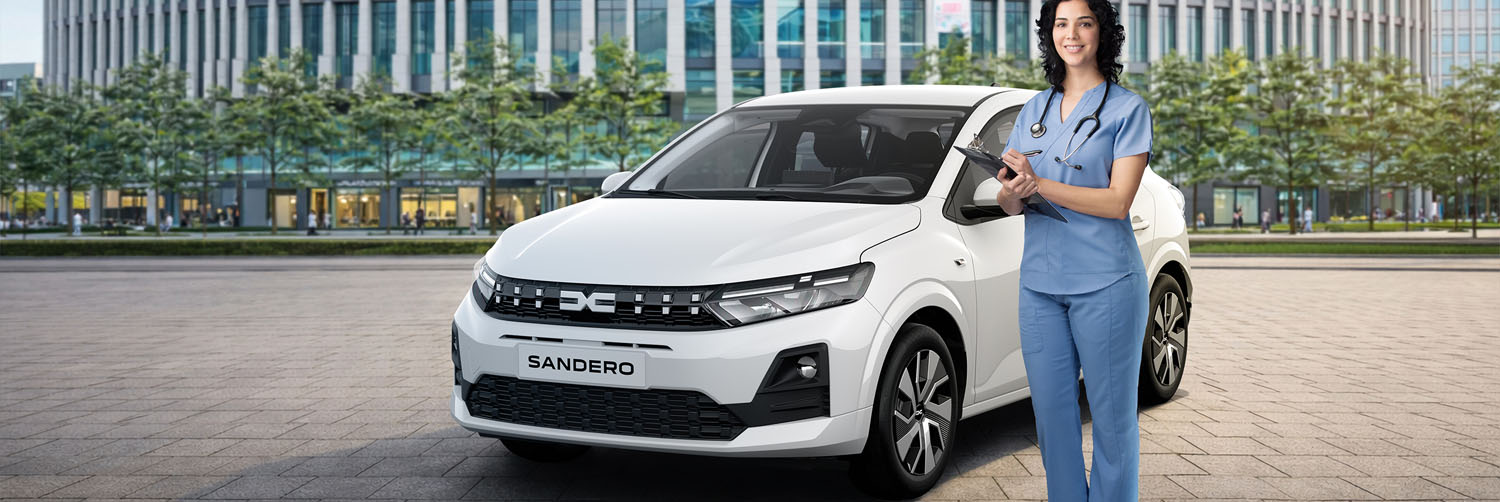 Das Bild zeigt einen weissen Dacia Sandero der vor einem großen und moderenen Bürogebäude parkt. Neben dem Auto steht eine Frau mit einem blauen Krankenhaus Kasack.