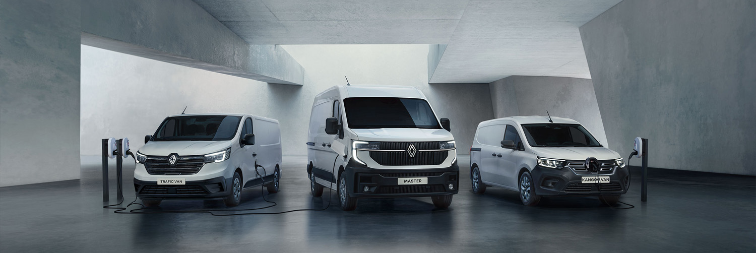 Drei weiße E-Transporter in einer modernen Betonhalle die gerade aufladen. Die Transporter sind 3 unterschiedliche Modelle von einem großen Transporter bis zu einem kleinen.